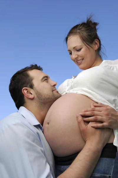 Чоловік цілує вагітний живіт своєї дружини — стокове фото