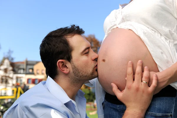 Husband kissing pregnant belly of his wife — Stock Photo, Image