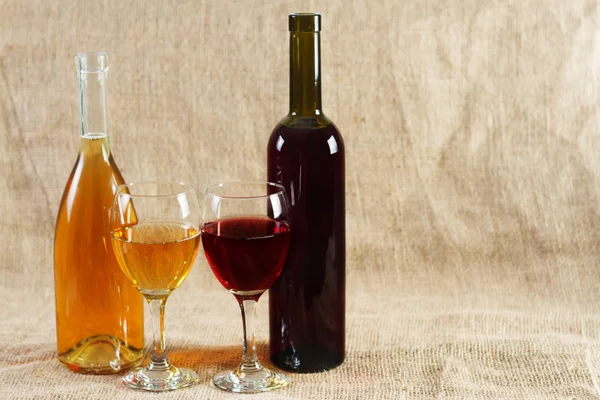 Copas y botellas de vino sobre fondo vintage —  Fotos de Stock