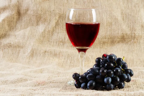 Vino tinto y uvas sobre fondo vintage — Foto de Stock