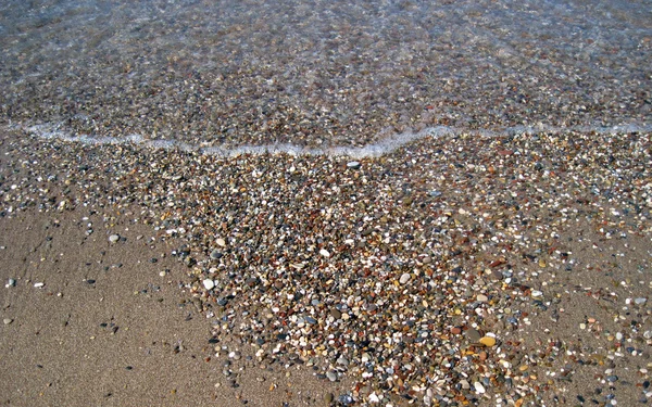 Песок и галька на берегу моря — стоковое фото