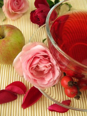 Fruits tea with rose hips, apples and rose flowers clipart