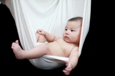 çıplak bebek uyku izole bir siyah arka plan üzerine beyaz hamak askı.
