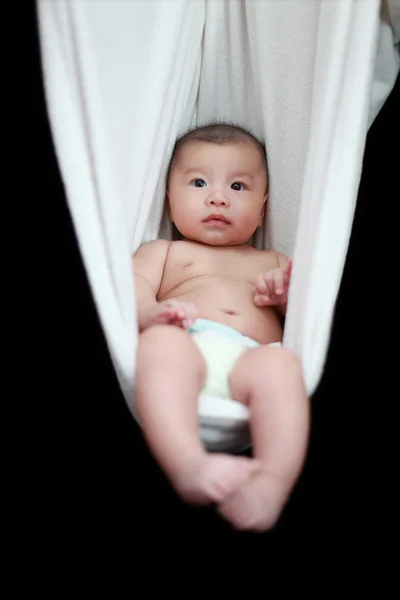 Meztelen baba alszik a fehér függőágy hevedert, elszigetelt, a fekete háttér. — Stock Fotó