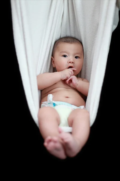 裸体婴儿睡在白色的吊床索具，黑色背景上孤立. — 图库照片