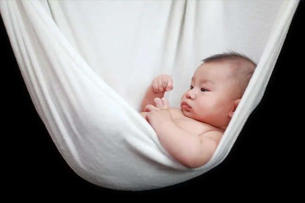 Meztelen baba alszik a fehér függőágy hevedert, elszigetelt, a fekete háttér. — Stock Fotó