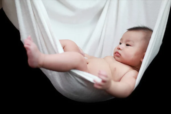 stock image Naked Baby sleeping in White Hammock Sling, isolated on a black background.