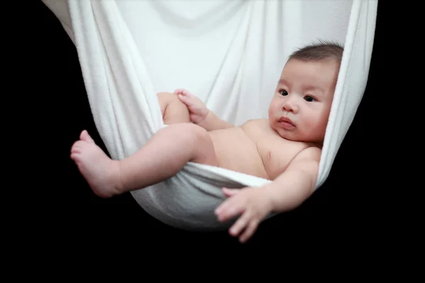 stock image Naked Baby sleeping in White Hammock Sling, isolated on a black background.