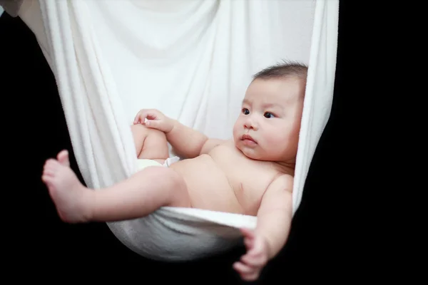 stock image Naked Baby sleeping in White Hammock Sling, isolated on a black background.