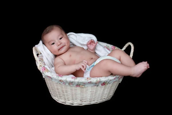 Söt baby i korg med svart bakgrund — Stockfoto