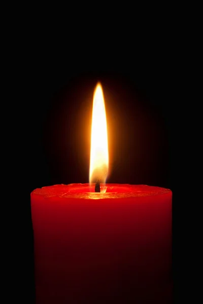 Hořící červenou svíčku před černým pozadím — Stock fotografie