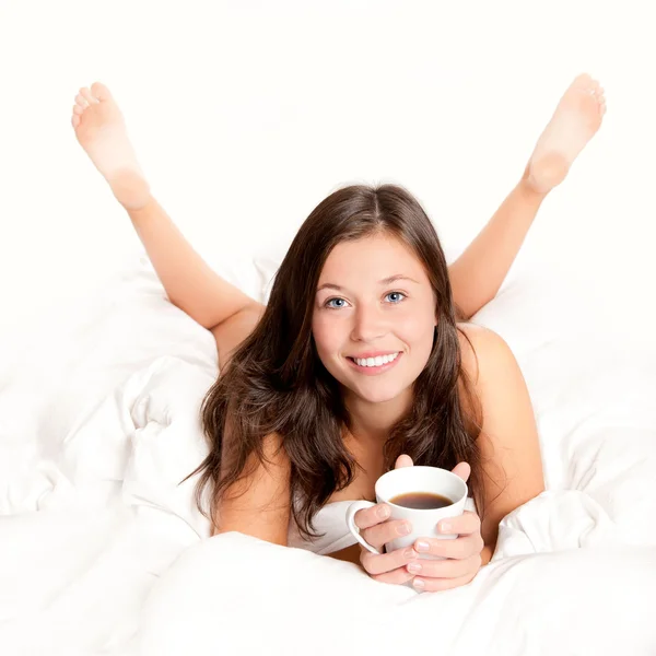 Beautiful young woman drinking coffee in bed — Stock Photo, Image