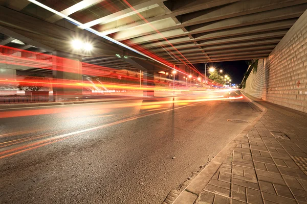 Trilhas de luz sob o viaduto — Fotografia de Stock