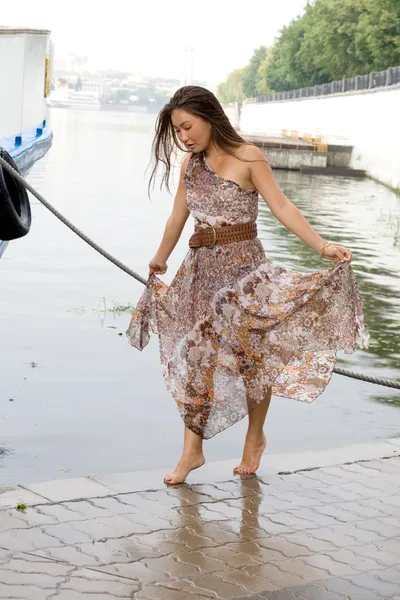 Красива дівчина, що йде біля річки — стокове фото