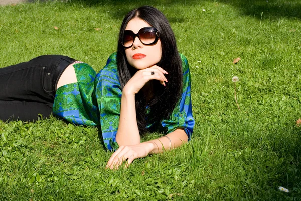 Meisje liggend op gras in park — Stockfoto