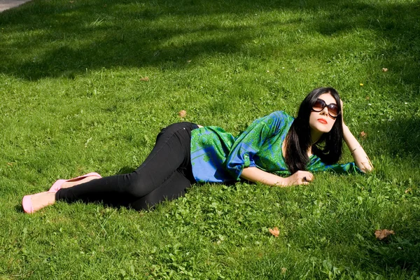Fille couchée sur l'herbe dans le parc — Photo
