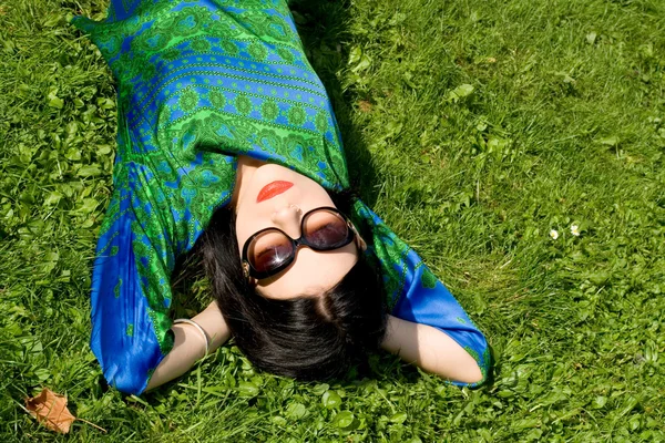 Chica acostada en la hierba en el parque — Foto de Stock