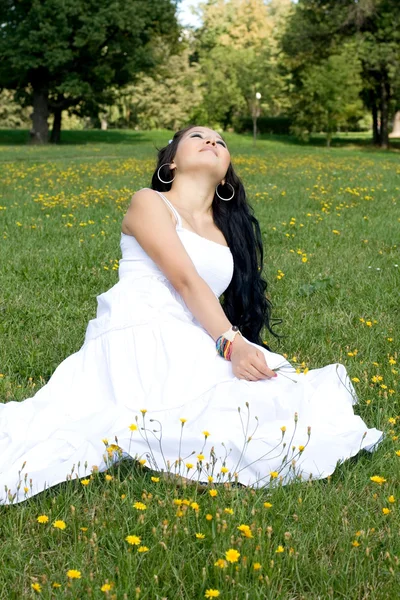 Mooi zwangere meisje, zittend op het gras — Stockfoto