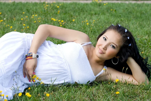 草の上に横たわる美しい妊娠中の女の子 — ストック写真