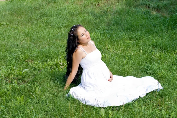 美丽的怀孕女孩坐在草地上 — Φωτογραφία Αρχείου