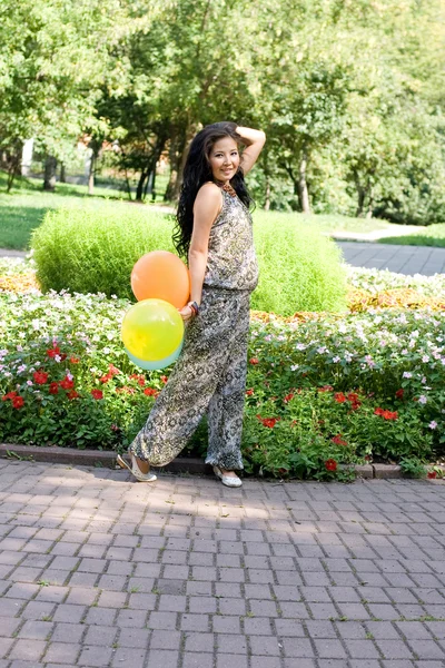 Радостная беременная девушка с цветными воздушными шарами — стоковое фото