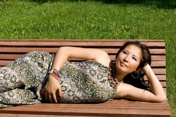 Krásná těhotná dívka ležela na lavičce — Stock fotografie