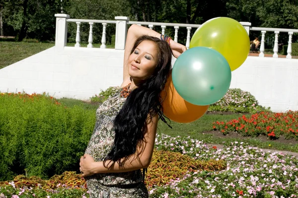 Joyful pregnant girl with colorful balloons — Stockfoto