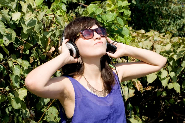 Mädchen hört Musik über Kopfhörer Stockbild