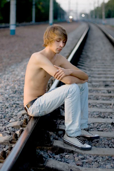 Handsome man walking near rails Stock Photo