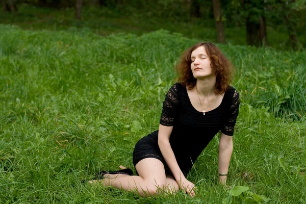 Hermosa chica sentada en la hierba — Foto de Stock