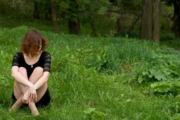 Piękna dziewczyna siedzi na trawie — Zdjęcie stockowe