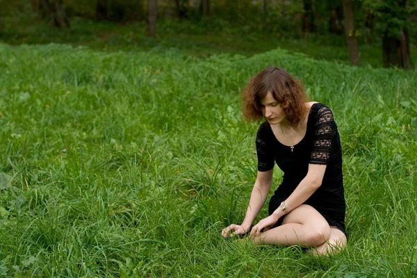 Красива дівчина сидить на траві — стокове фото