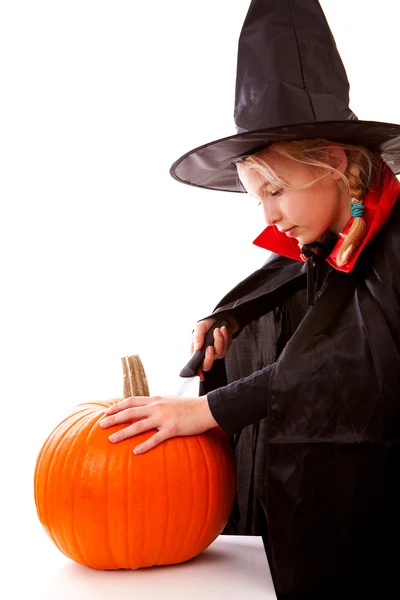 Dressed up girl is cutting pumpkin — Stock Photo, Image