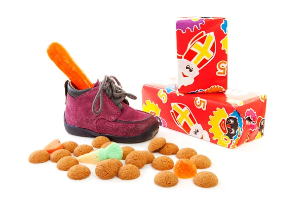 Lila kis gyermek cipő, ajándékok és pepernoten — Stock Fotó