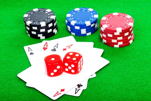 Four aces playing cards and red dice on green background — Stock Photo, Image
