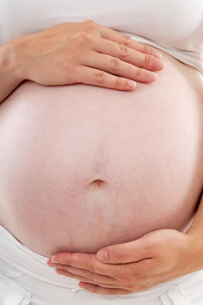 Matka ruce držící těhotné břicho — Stock fotografie