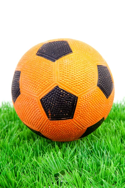 Orange soccer ball on plastic grass — Stock Photo, Image