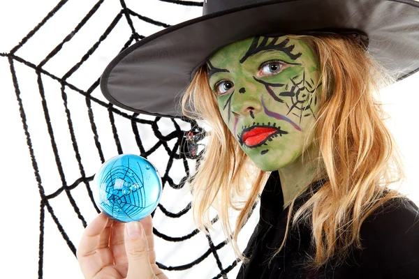Zelená halloween čarodějnice dívka v detailním drží velký modrý mramor — Stock fotografie