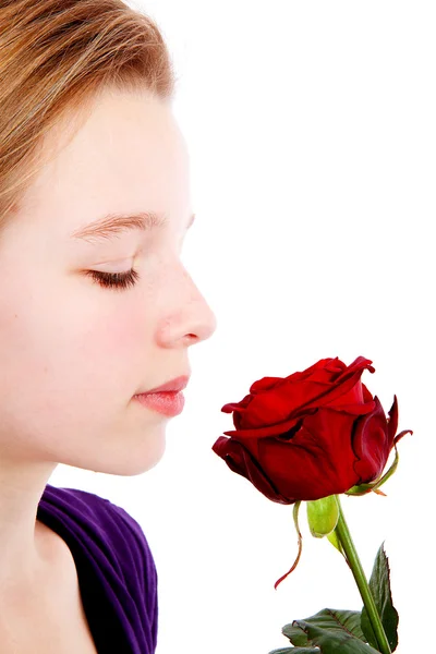年轻女孩嗅到的特写镜头中的一朵红玫瑰 — 图库照片