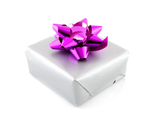 Подарок, завернутый в серебряную бумагу и розовую ленту — стоковое фото