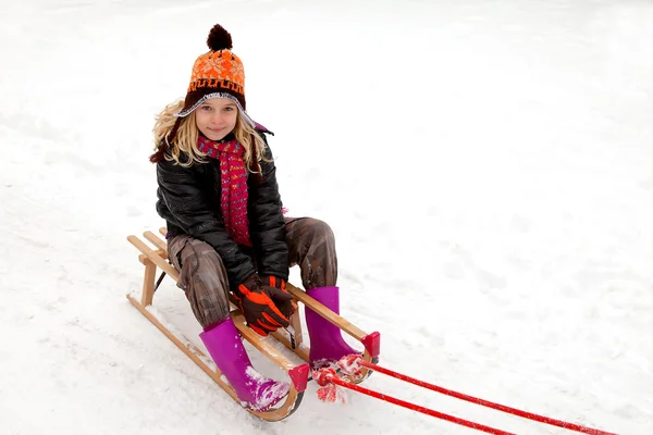 Girl on sled in the snow — Stock Photo, Image