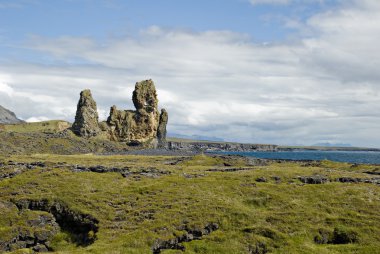 High rocks in the middle of lava field clipart