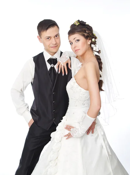 Mooie bruid en bruidegom permanent op witte achtergrond. bruiloft — Stockfoto