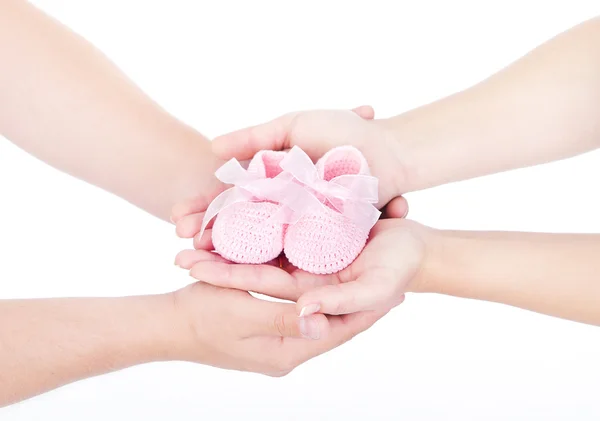 Mors og fars hender holder rosa, nyfødte babystøvler. O – stockfoto