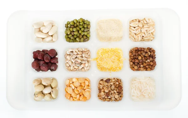 stock image Set of twelve sorts of cereals and grains on white tray. Closeup