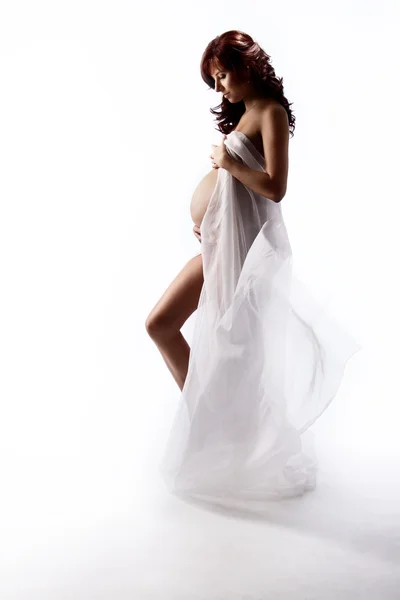Pregnant woman in white waving flying dress. Looking down at be — Stock Photo, Image
