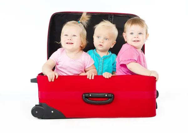 Crianças sentadas dentro da mala vermelha — Fotografia de Stock