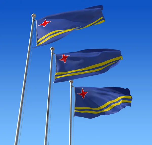 Drie vlaggen van aruba tegen blauwe hemel. — Stockfoto