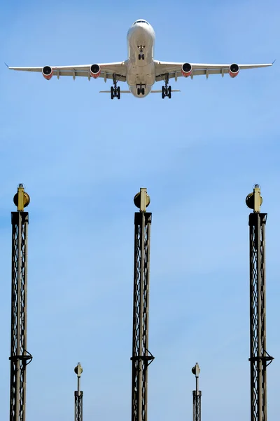 Самолет над огнями в аэропорту — стоковое фото