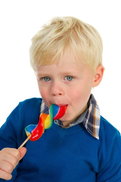 一个金发碧眼的小男孩吃棒棒糖的肖像 — 图库照片